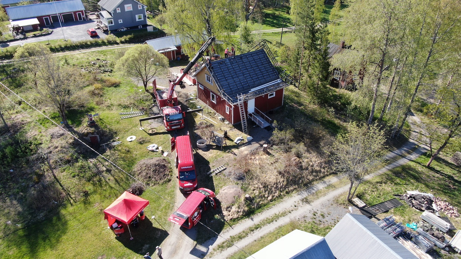 Nosturiavusteinen kattoremontti menelillään kaksikerroksisen puutalon katolla